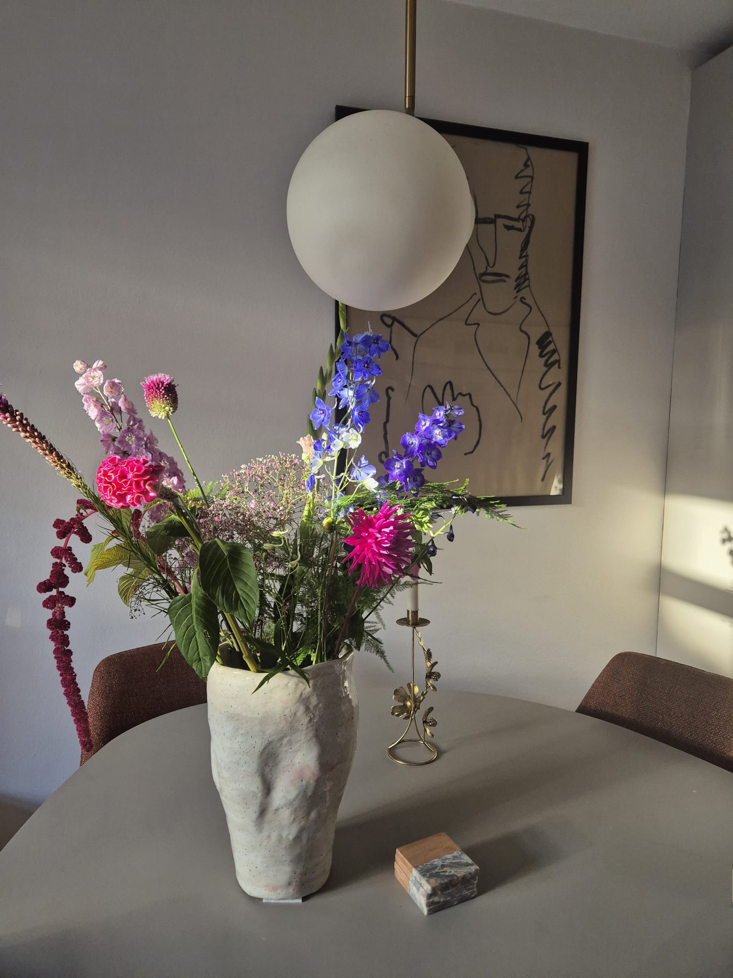 Handgevormde vaas met kleurrijk boeket op tafel